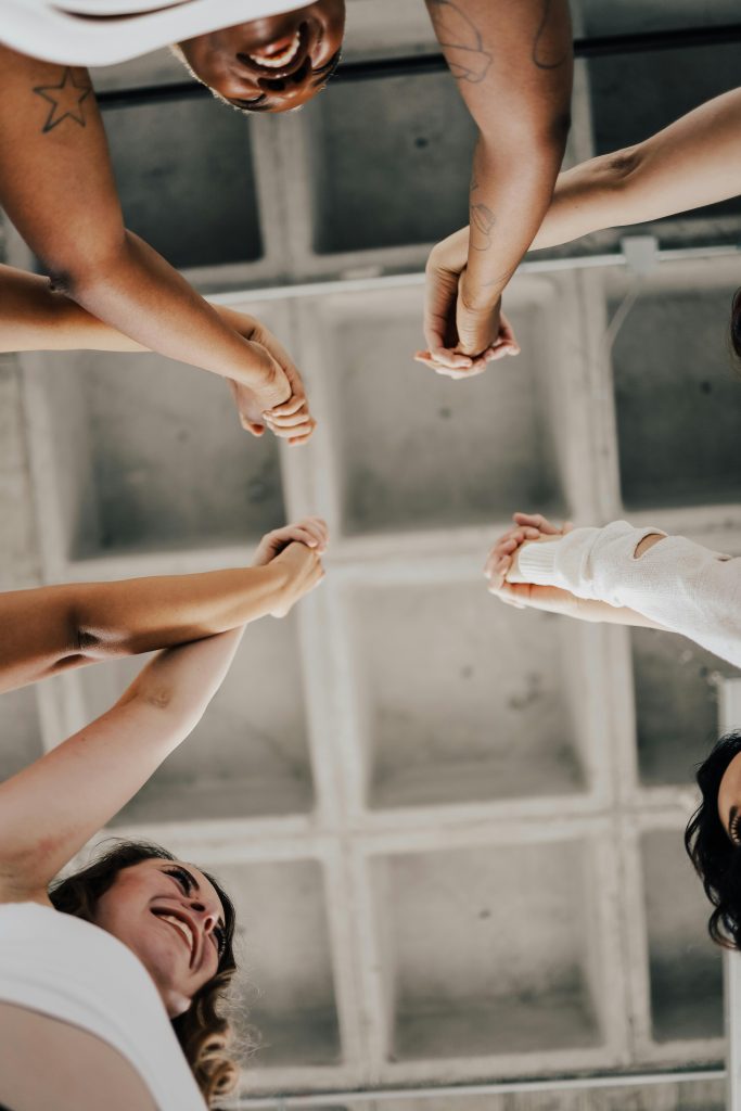 A diverse group of women united with raised hands, symbolizing community and empowerment.