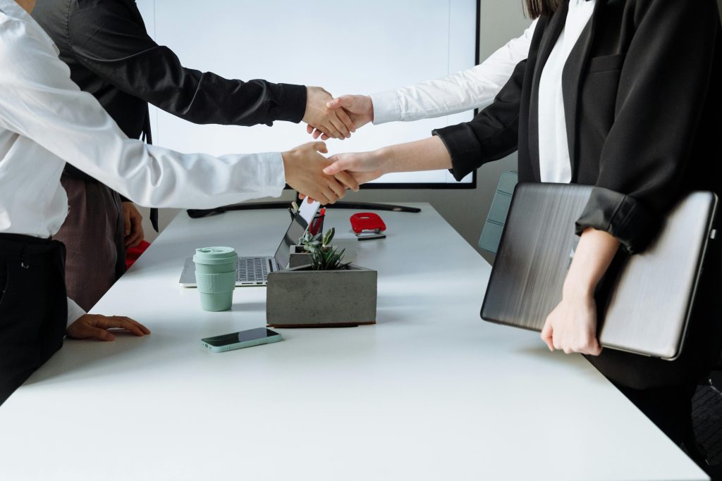 pexels-photo-7651924-7651924 Professionals sealing a deal with a handshake across a conference table during a business meeting.